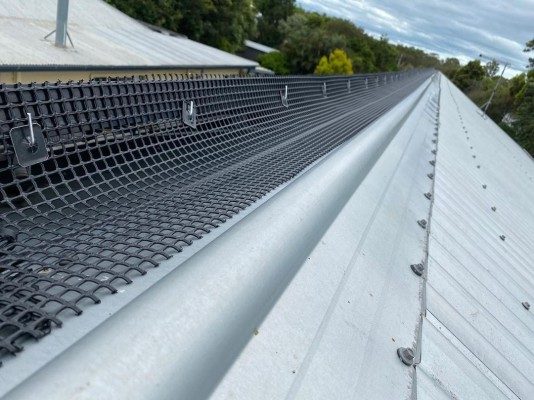Person securing solar panels on a roof